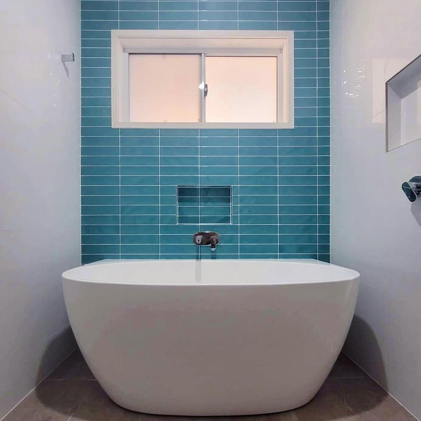 Blue feature tile behind a freestanding bath