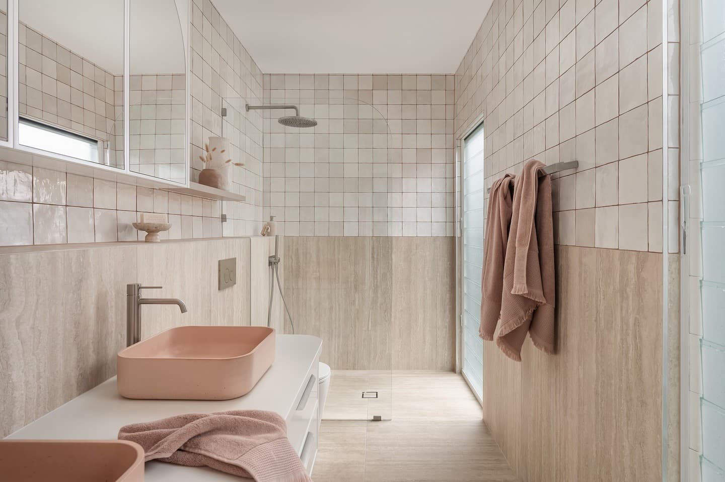 Travertine-toned bathroom with handmade square tiles