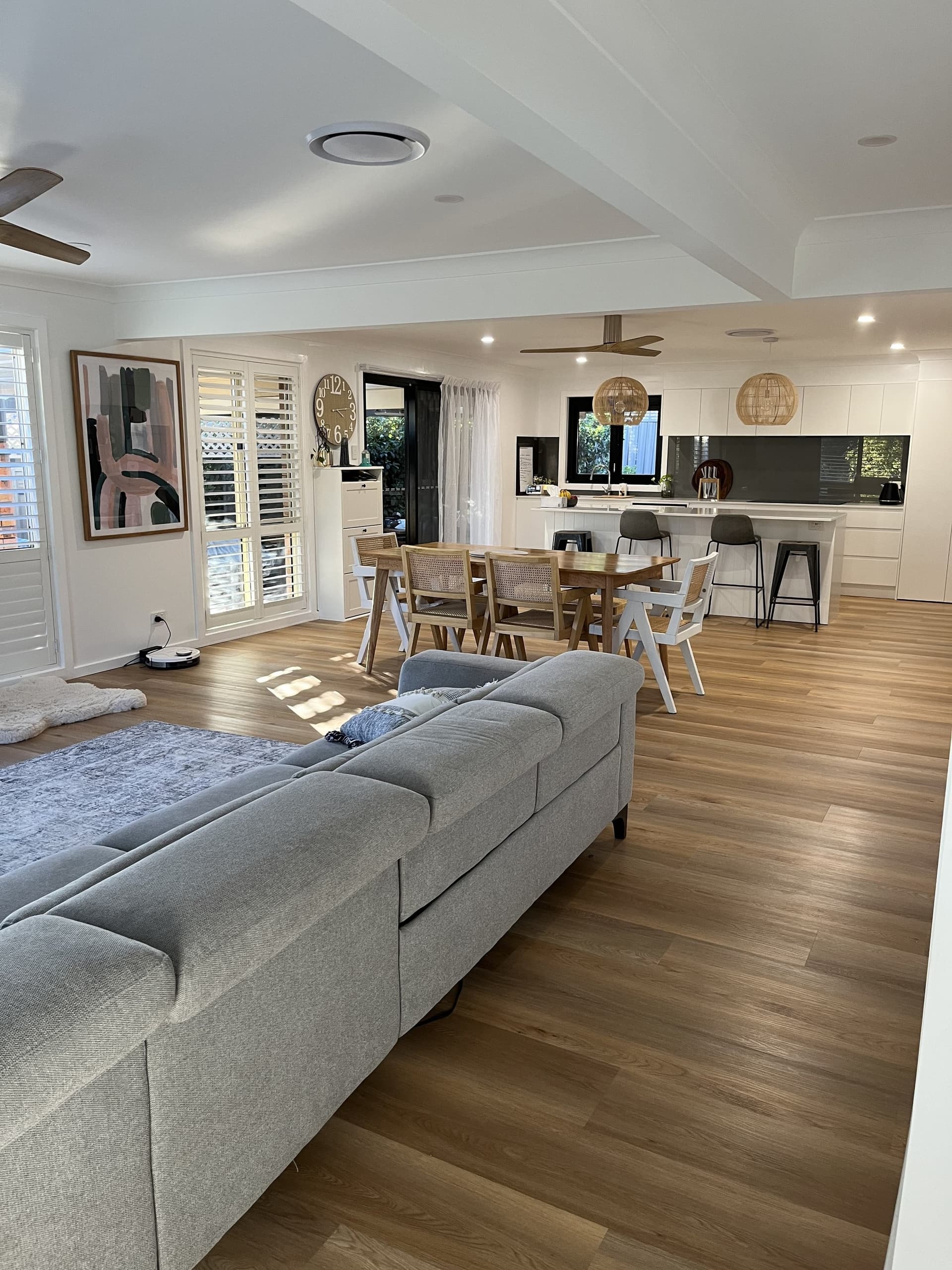 Living and dining with plantation shutters, from the kitchen side