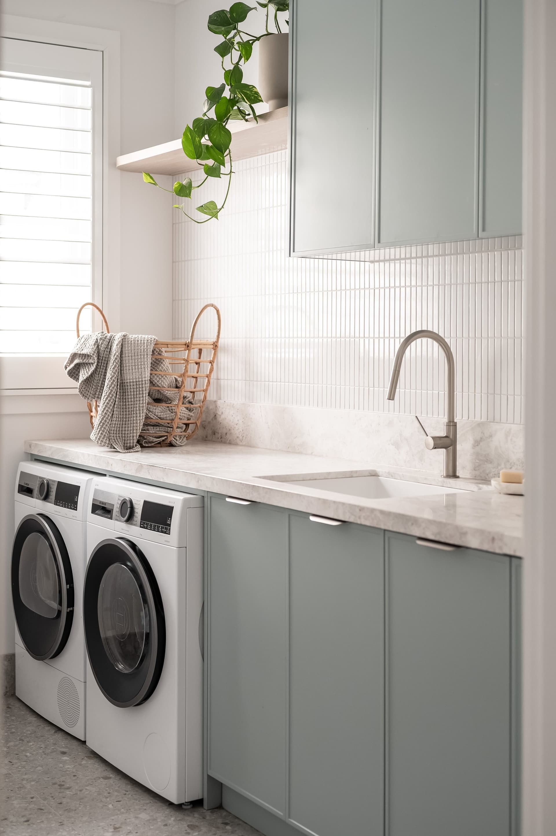 Laundry in sage joinery with a stone bench