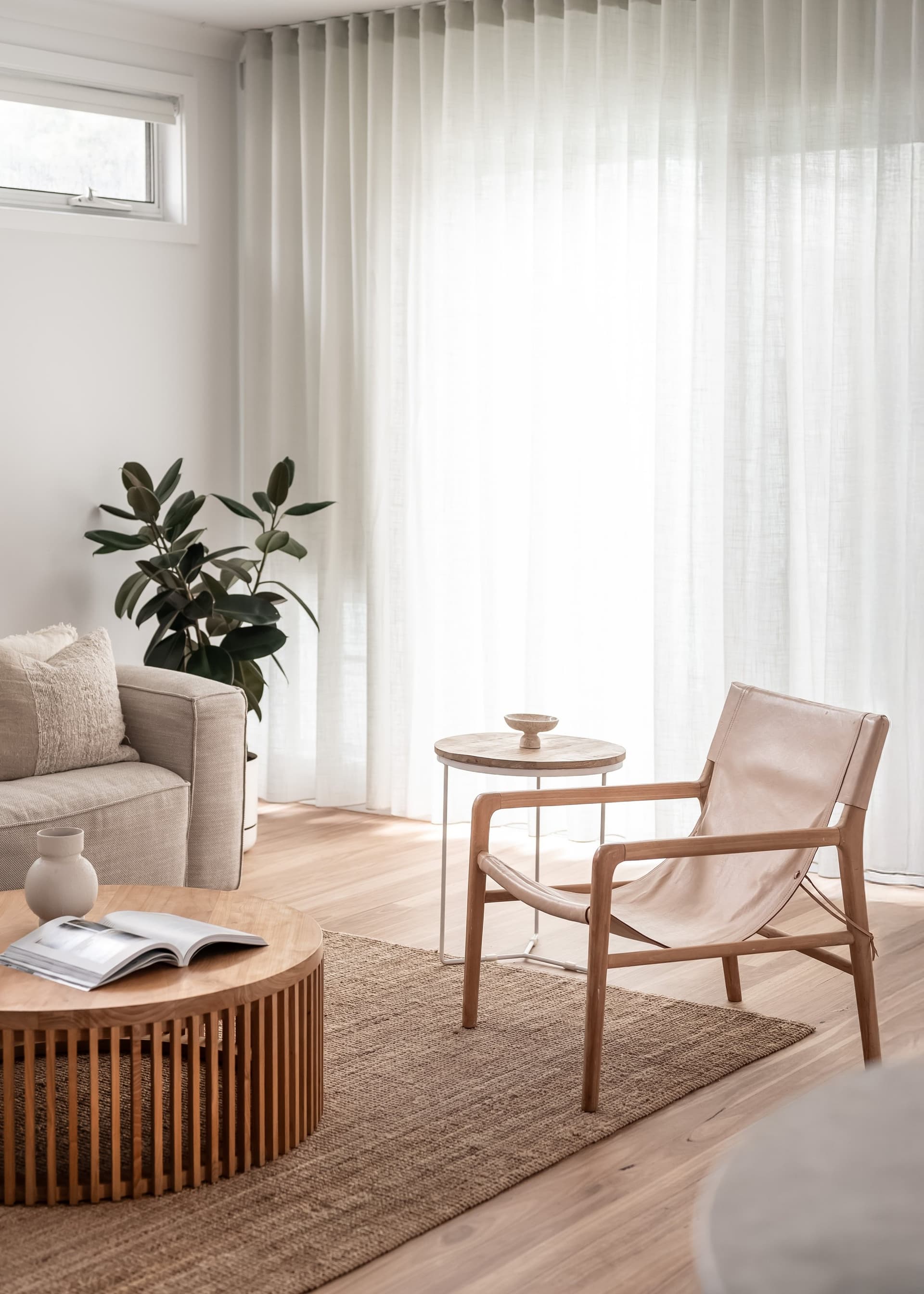 Reading corner with a leather chair against sheer curtains