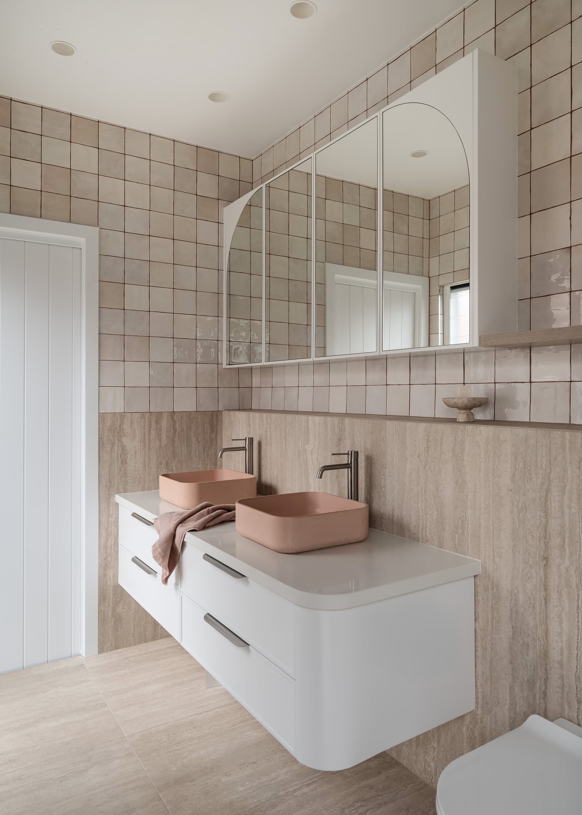 Arched mirror over a stone vanity