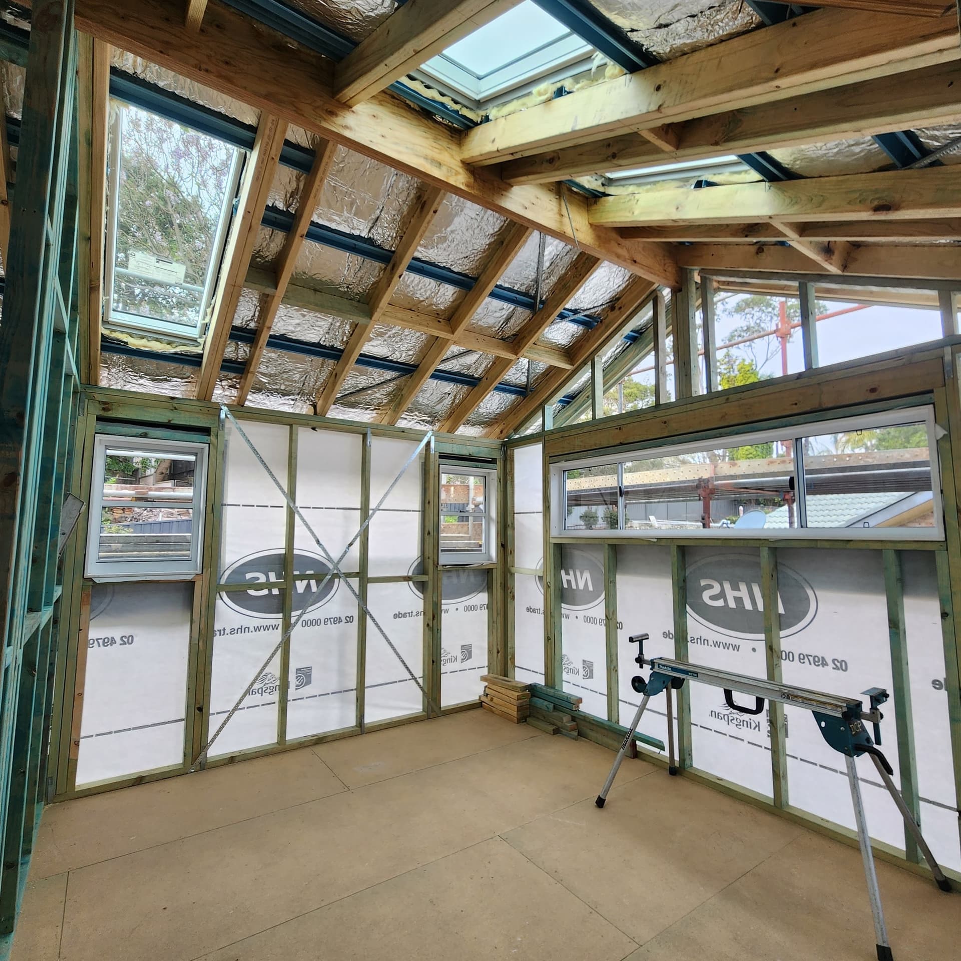 Timber frame of an extension in progress with skylights, built by Delaney Construction Projects