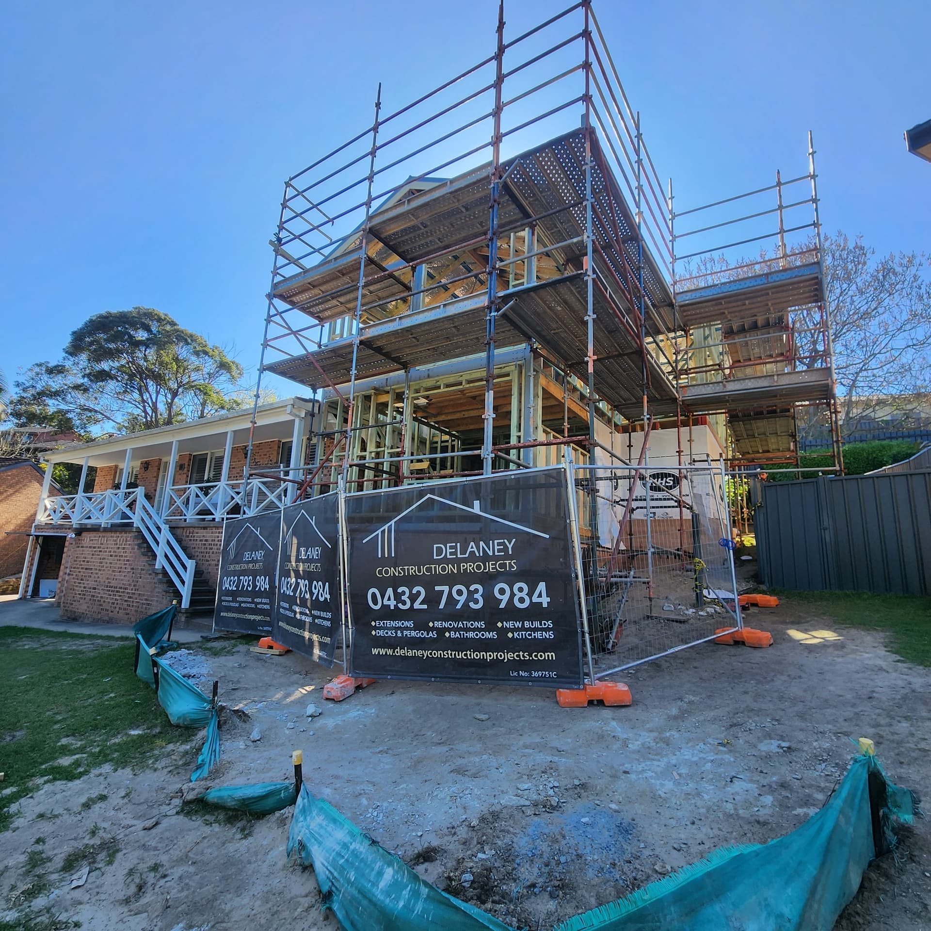 Two-storey frame under scaffold with the Delaney Construction Projects site sign