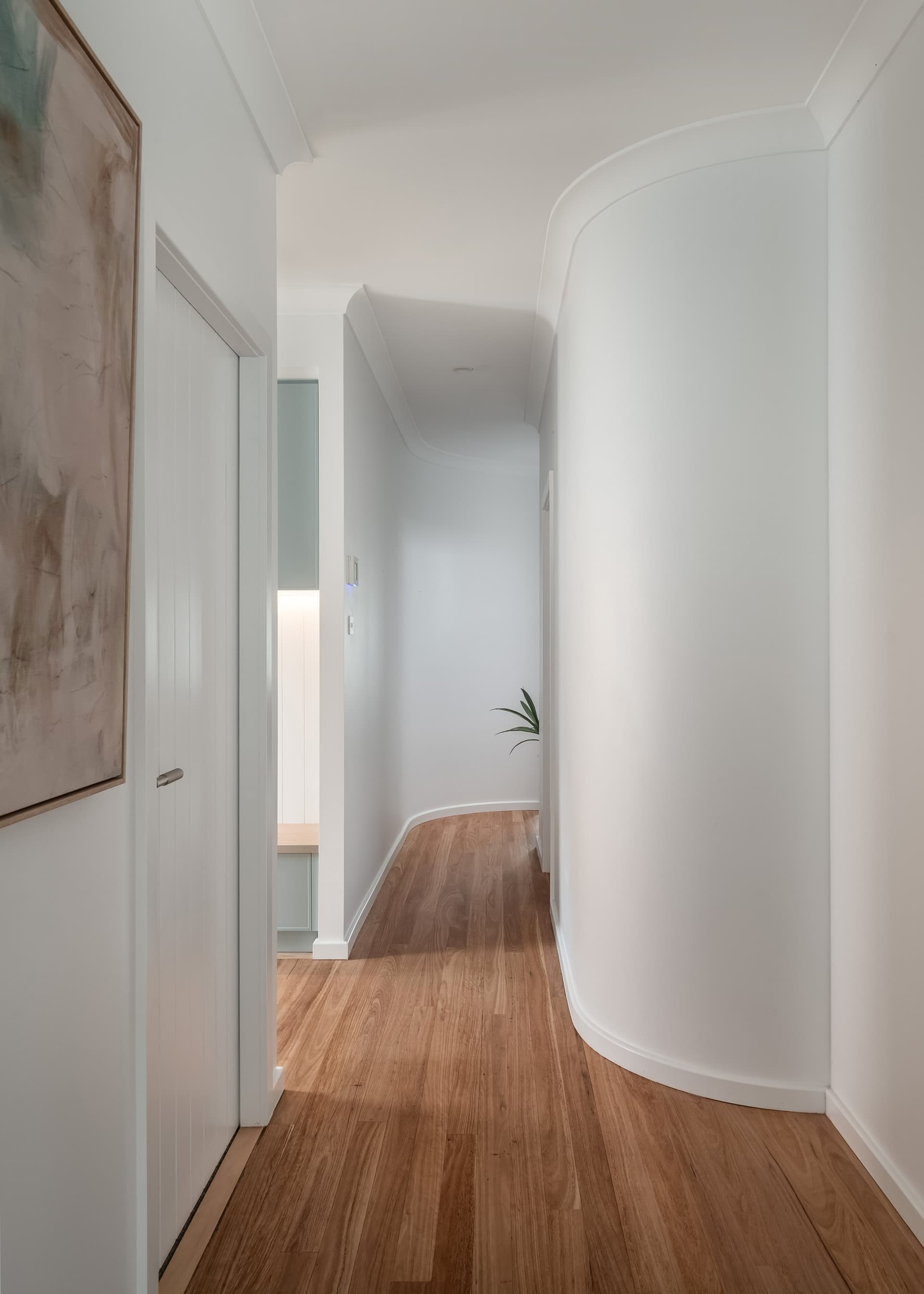 Curved hallway wall and timber floors in a renovation by Delaney Construction Projects