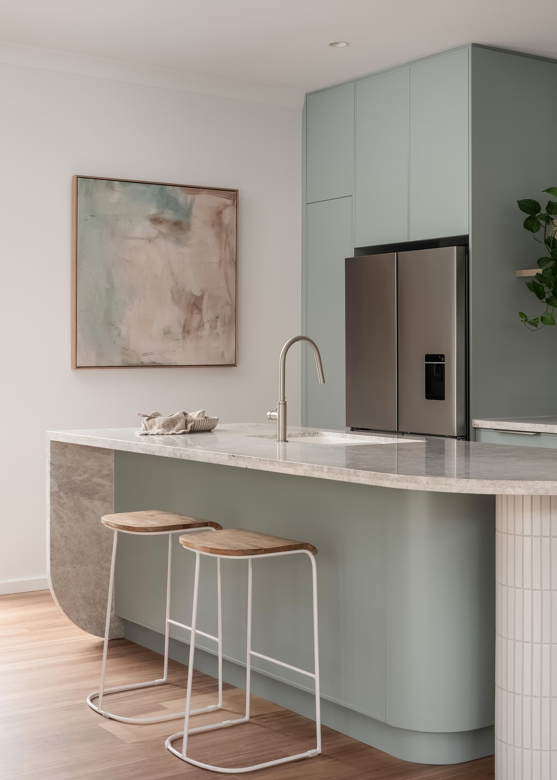 Renovated kitchen by Delaney Construction Projects — sage joinery, stone island and timber floors